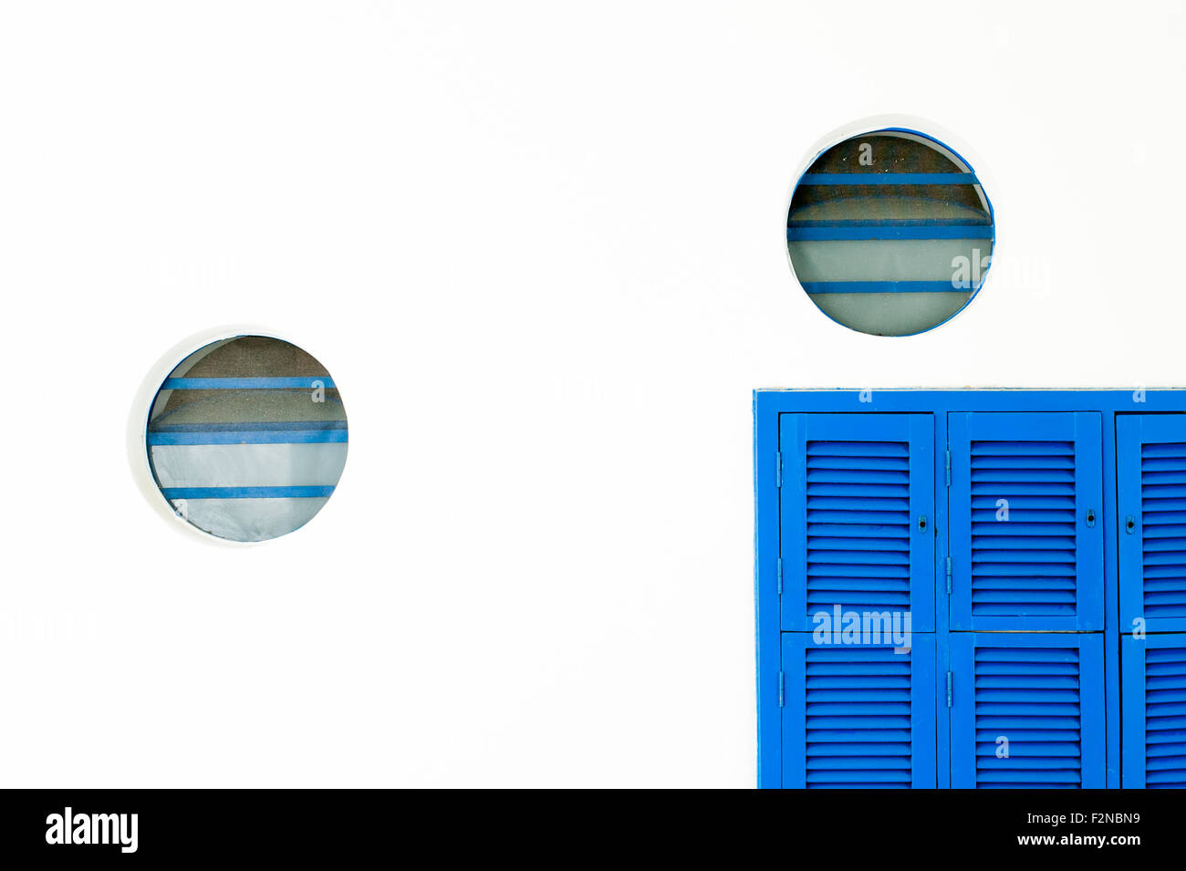 Blauen Verschluss und Rundfenstern an weißer Wand Stockfoto
