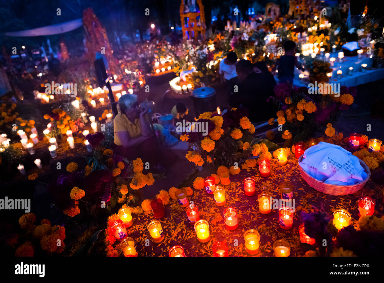 Mexikanische Familienmitglieder Kerzen und beten auf dem Friedhof im Laufe des Tages der toten Feier in Tzintzuntzan, Mexiko. Stockfoto