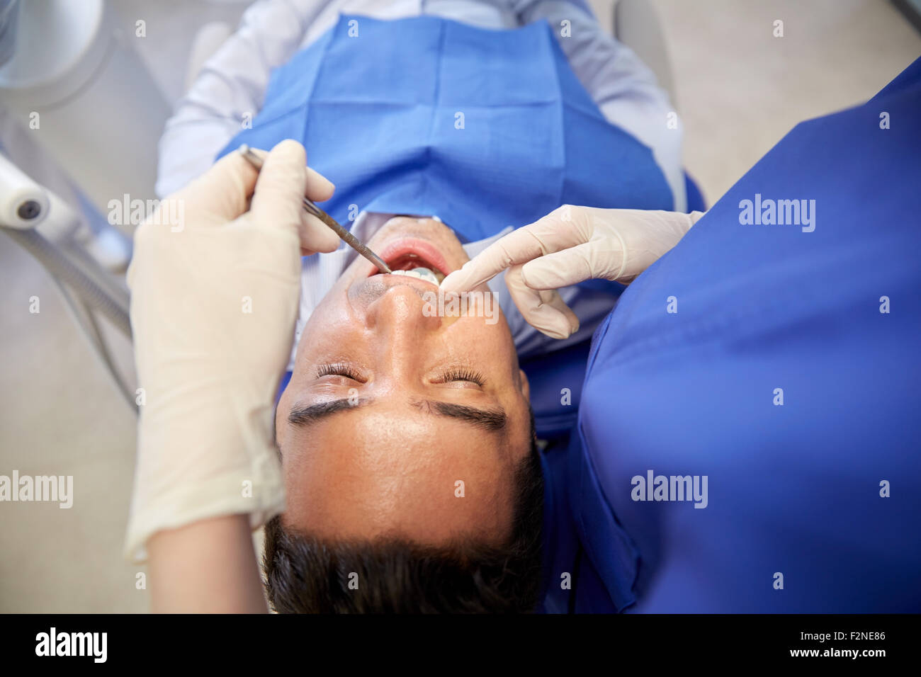 Nahaufnahme von Zahnarzt überprüfen männlichen Patienten Zähne Stockfoto