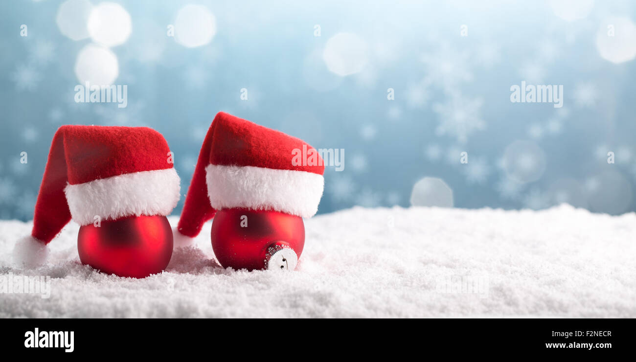 Weihnachtskugeln in den Hut des Weihnachtsmannes auf Schnee. Stockfoto