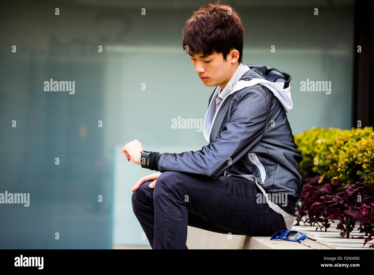 Asiatischer Mann überprüfen Armbanduhr in Stadt Stockfoto