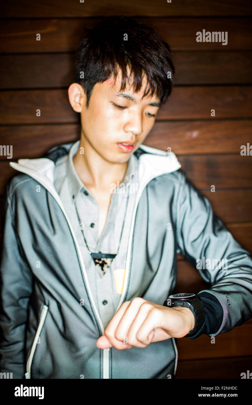 Asiatischer Mann Überprüfung Armbanduhr Stockfoto