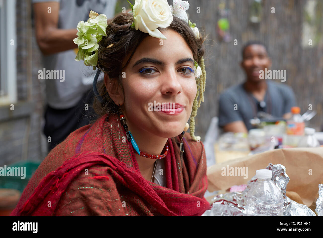 Lächelnde Frau mit Blumen und Schal hautnah Stockfoto