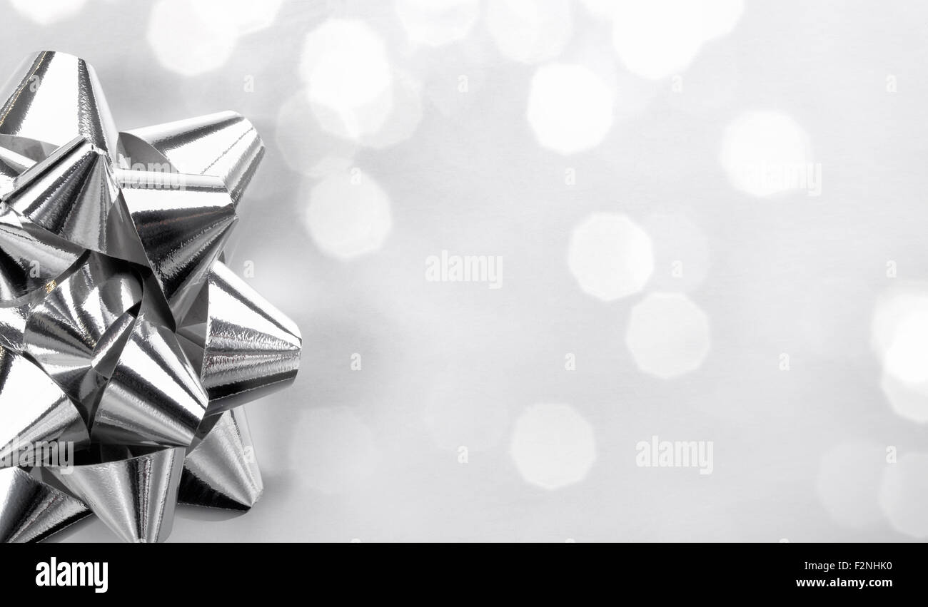Nahaufnahme des silbernen Bogens auf abstrakten Hintergrund, Weihnachtsdekoration. Stockfoto