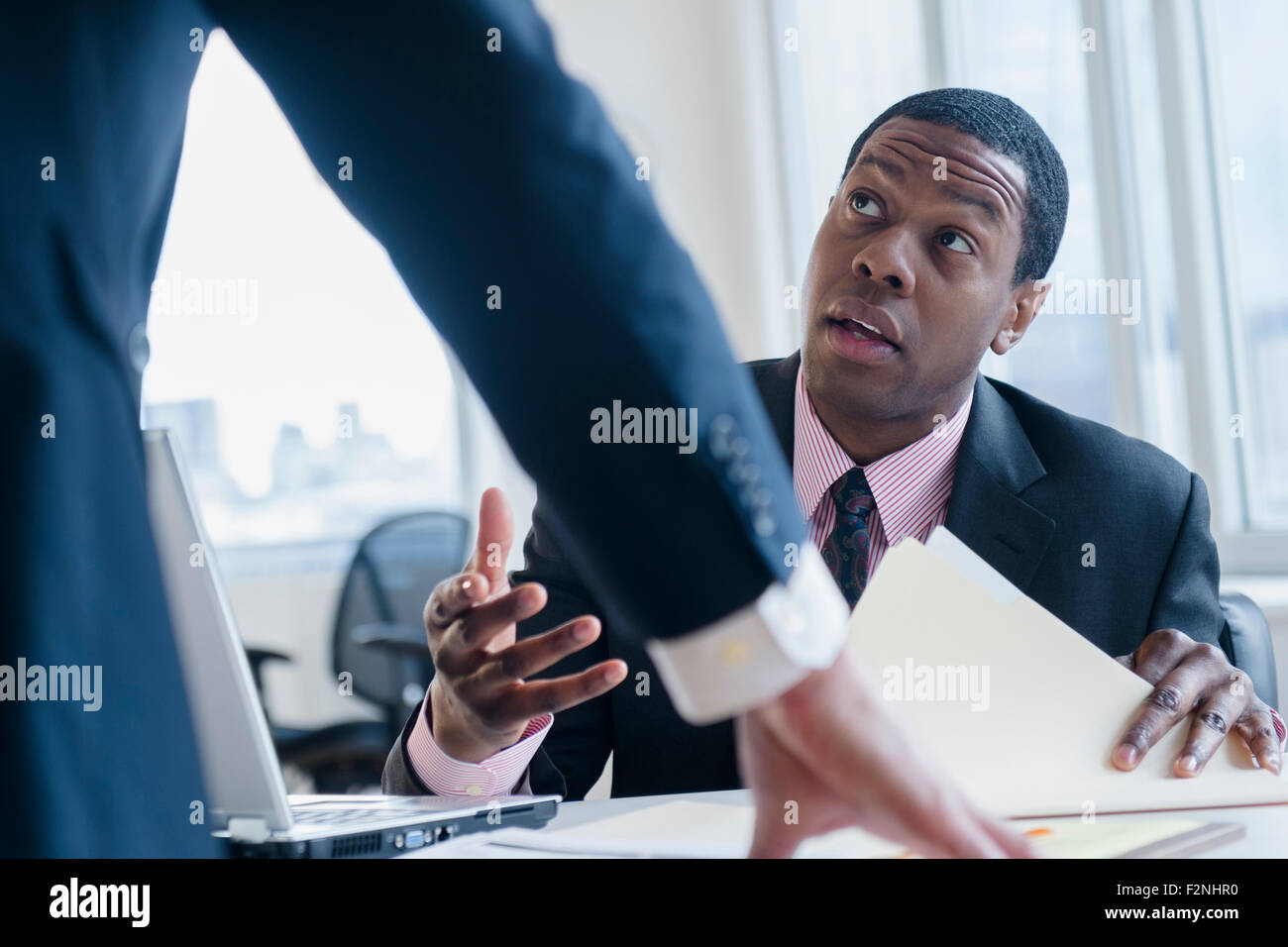 Geschäftsleute sprechen am Schreibtisch im Büro Stockfoto