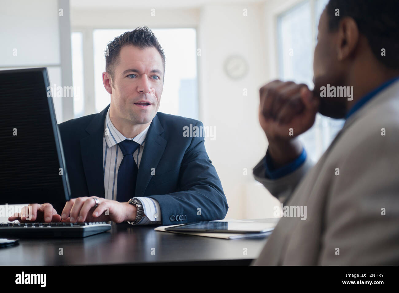 Geschäftsleute sprechen am Schreibtisch im Büro Stockfoto