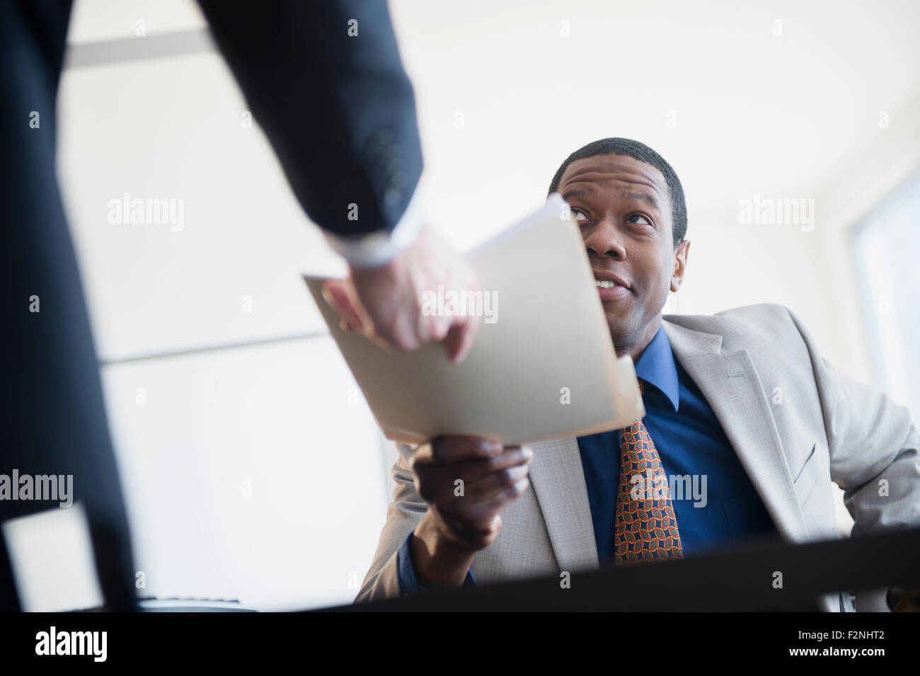 Geschäftsmann Übergabe Ordner an Chef im Büro Stockfoto