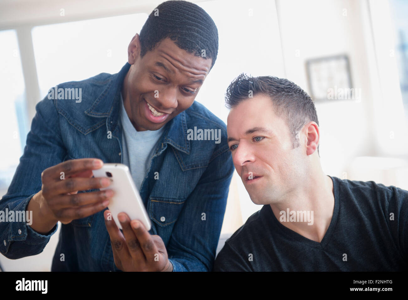 Männer lesen Handy im Büro Stockfoto