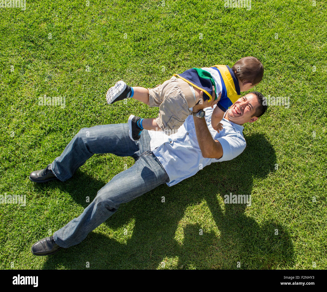 Erhöhte Ansicht der hispanischen Vater und Sohn spielen auf Rasen Stockfoto