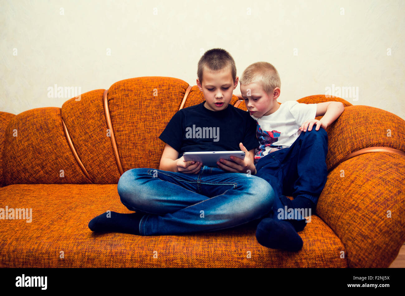 Kaukasischen Brüder mit digital-Tablette auf sofa Stockfoto