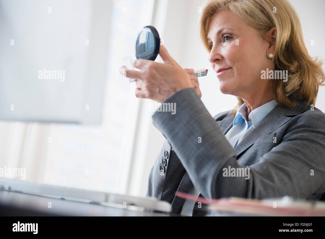 Kaukasische Geschäftsfrau Schminken im Büro Stockfoto