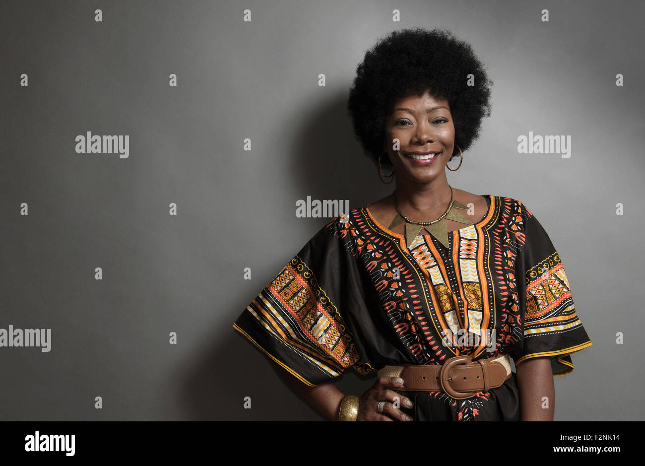Afroamerikanische Frau lächelnd mit Hand auf der Hüfte Stockfoto