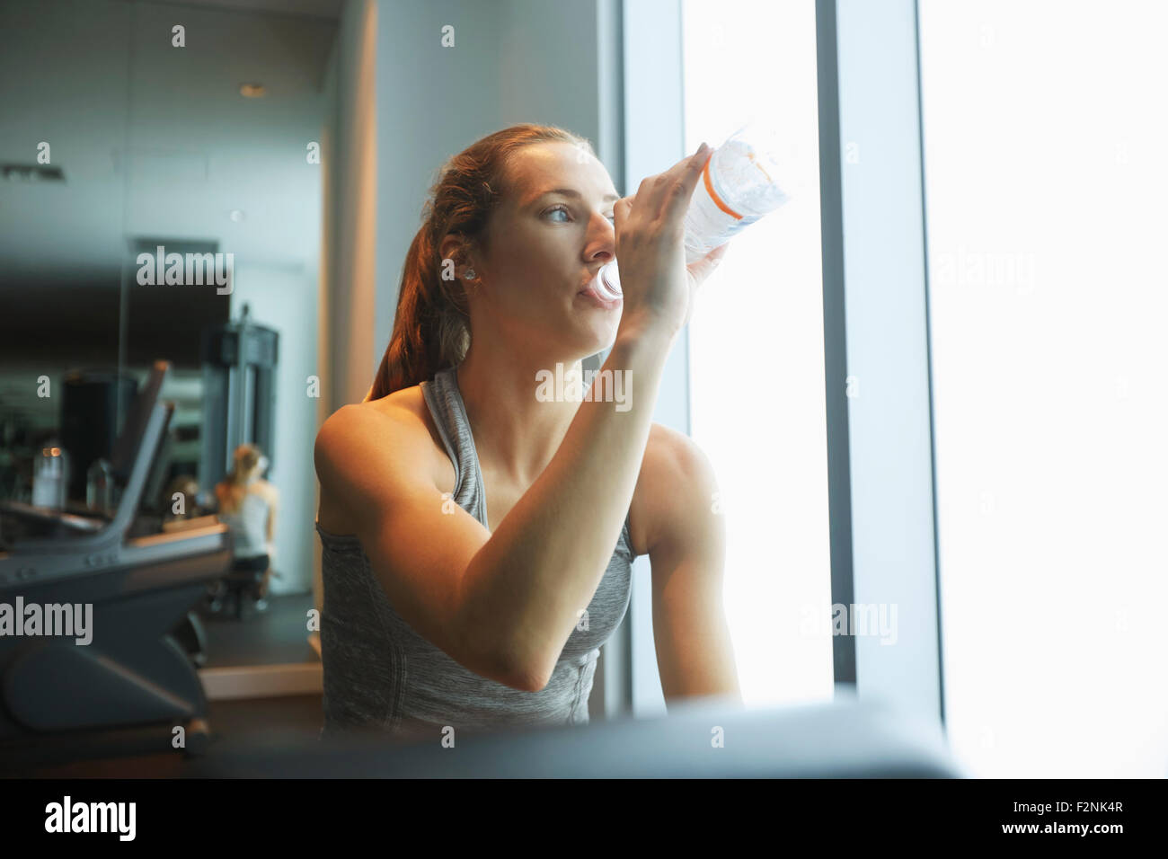 Frau Trinkwasser Flasche im Fitness-Studio Stockfoto
