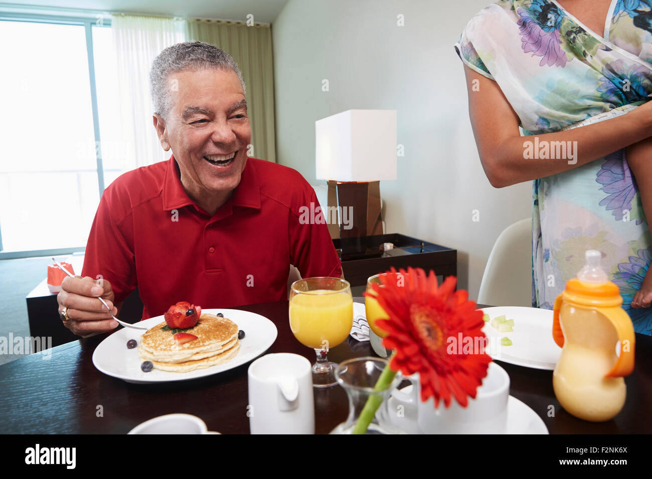 Vater und Tochter essen Pfannkuchen am Tisch Stockfoto