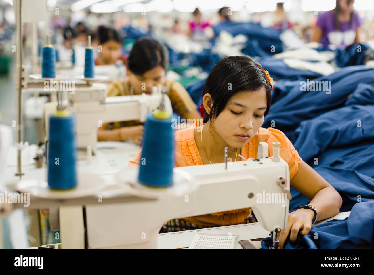Asiatische Arbeiter nähen Kleidung in Textilfabrik Stockfoto