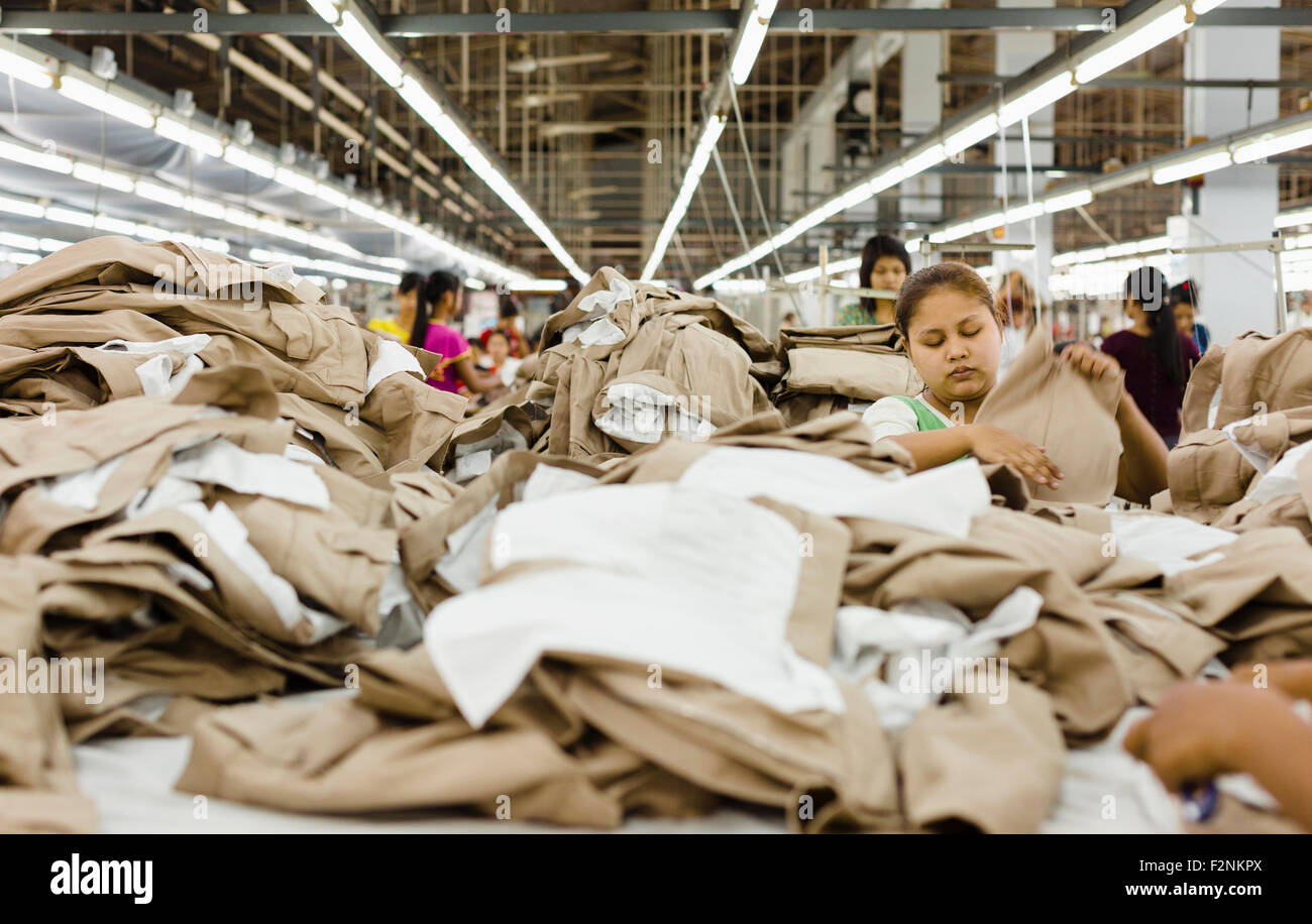 Arbeitnehmer, die Falten der Kleidung in Textilfabrik Stockfoto