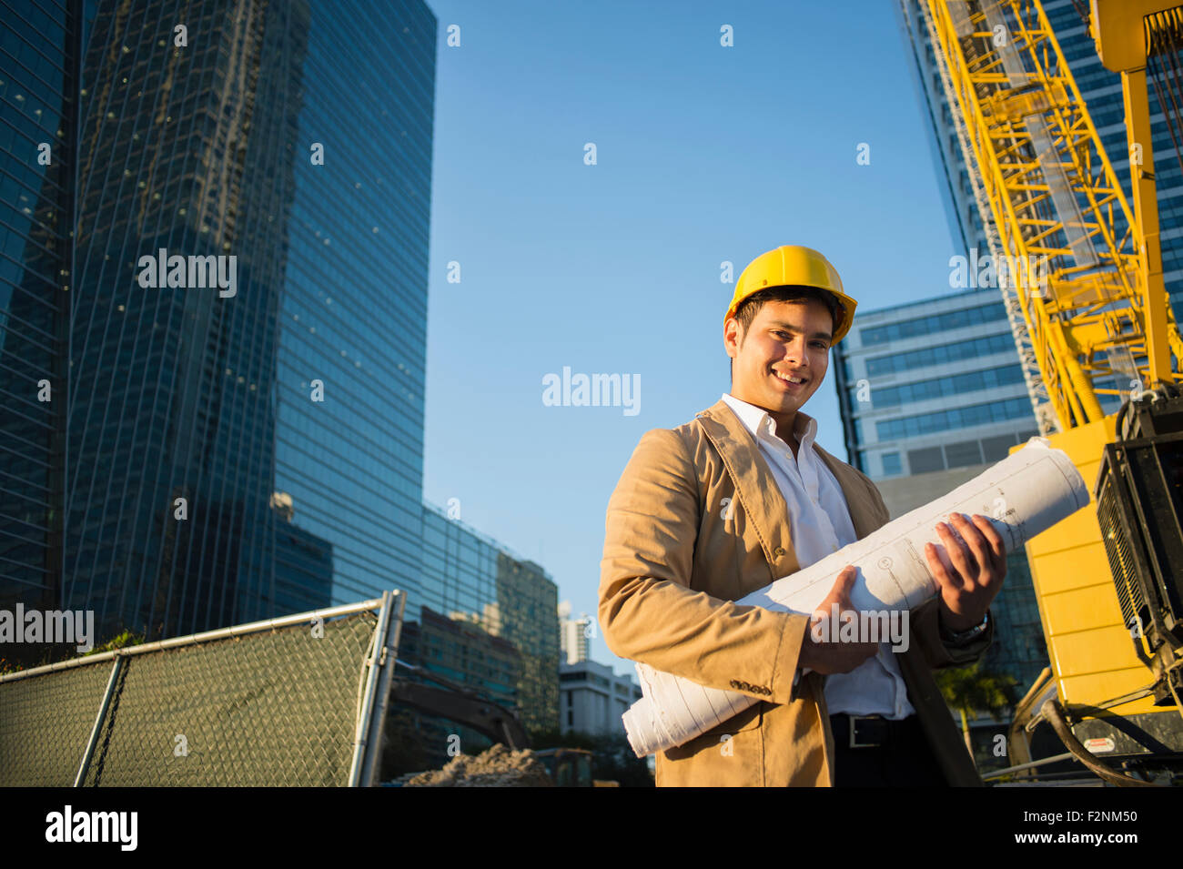 Gemischte Rassen Architekten halten Blaupausen auf Baustelle Stockfoto