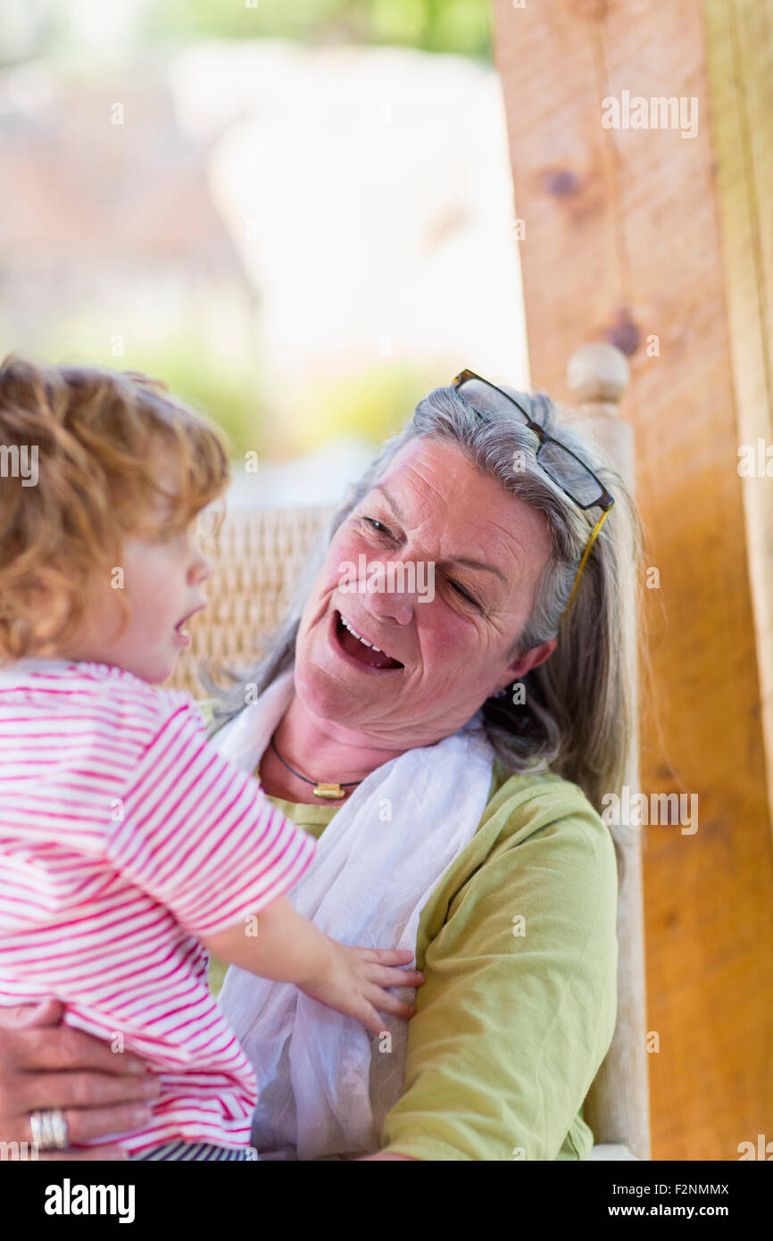 Kaukasische Frau Holding Enkel im Schaukelstuhl Stockfoto