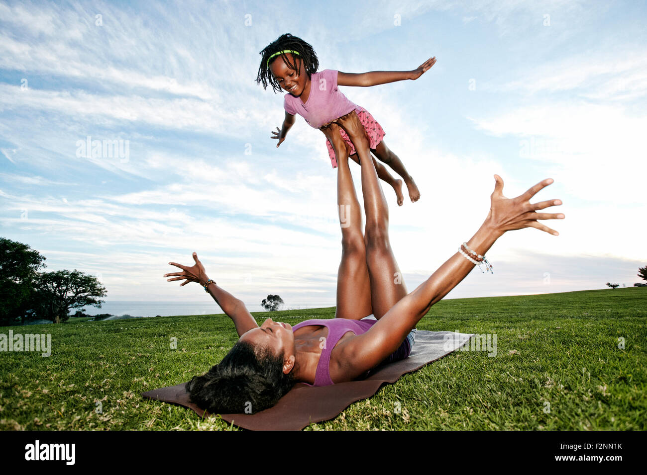 Mutter ausgleichende Tochter auf Beinen im park Stockfoto