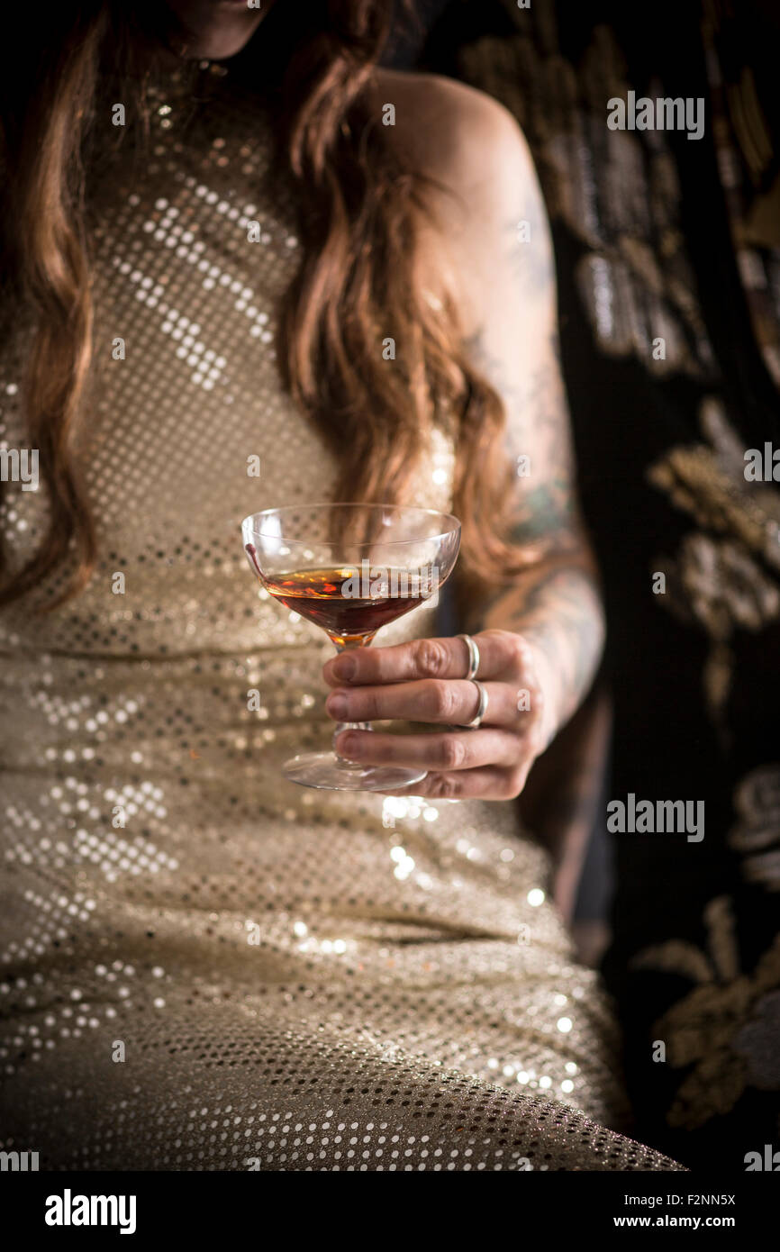 Kaukasische Frau im Abendkleid trinken cocktail Stockfoto