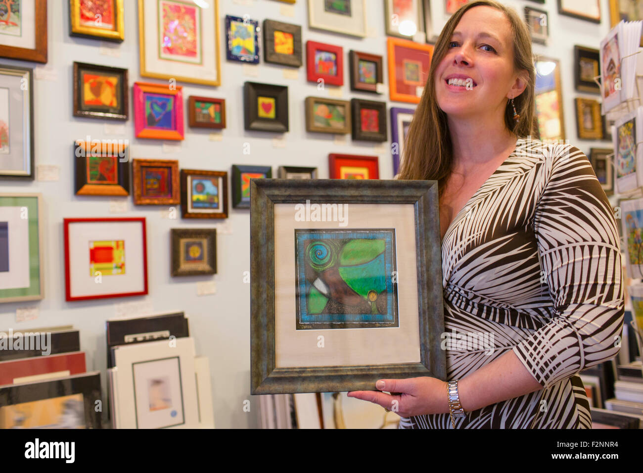 Kaukasische Künstler Kunstwerke in der Galerie hält Stockfoto