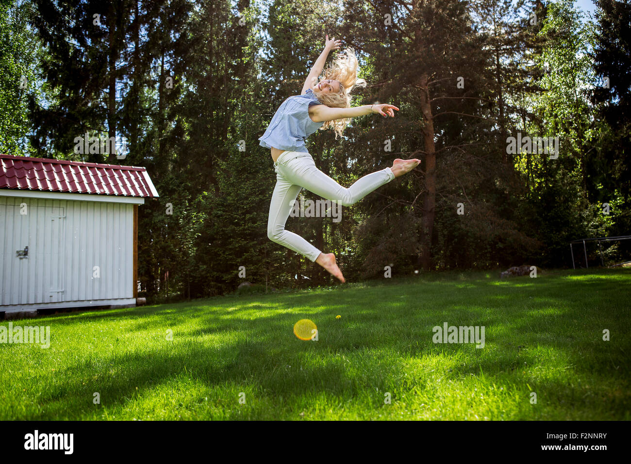 Frau springen vor Freude im Hinterhof Stockfoto