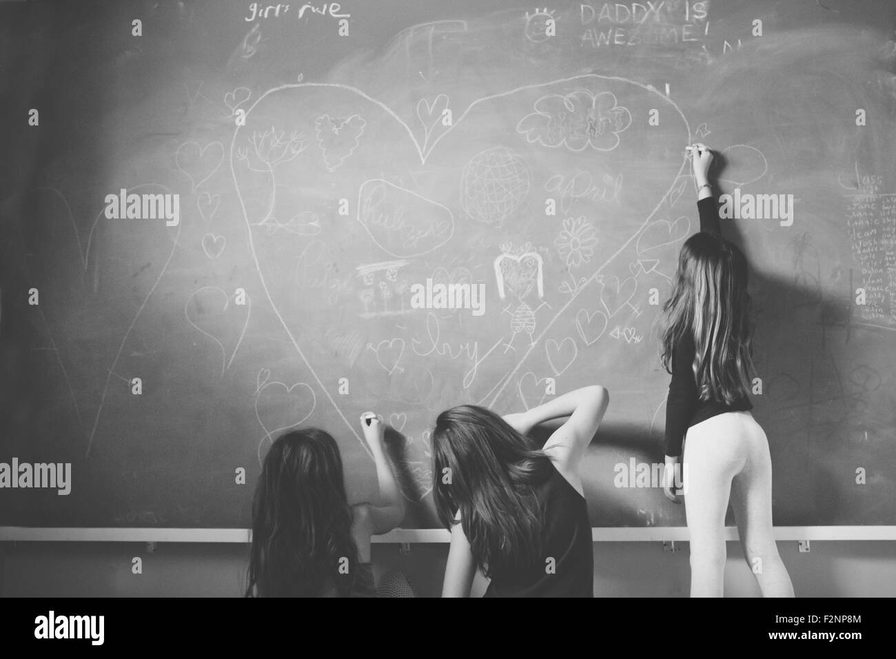 Kaukasische Mädchen zeichnen auf Klassenzimmer Tafel Stockfoto