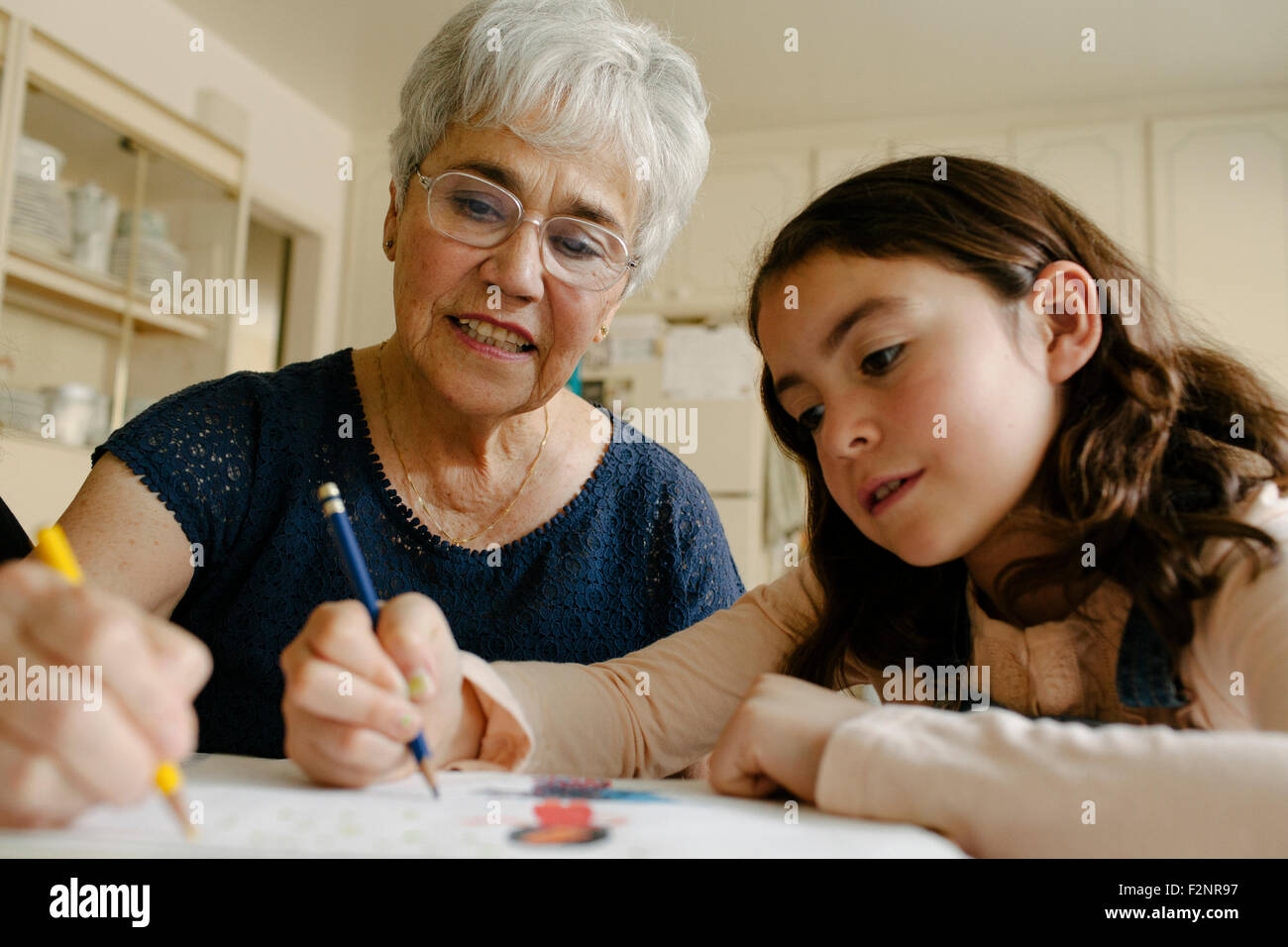 Großmutter und Enkelin Zeichnung am Tisch Stockfoto