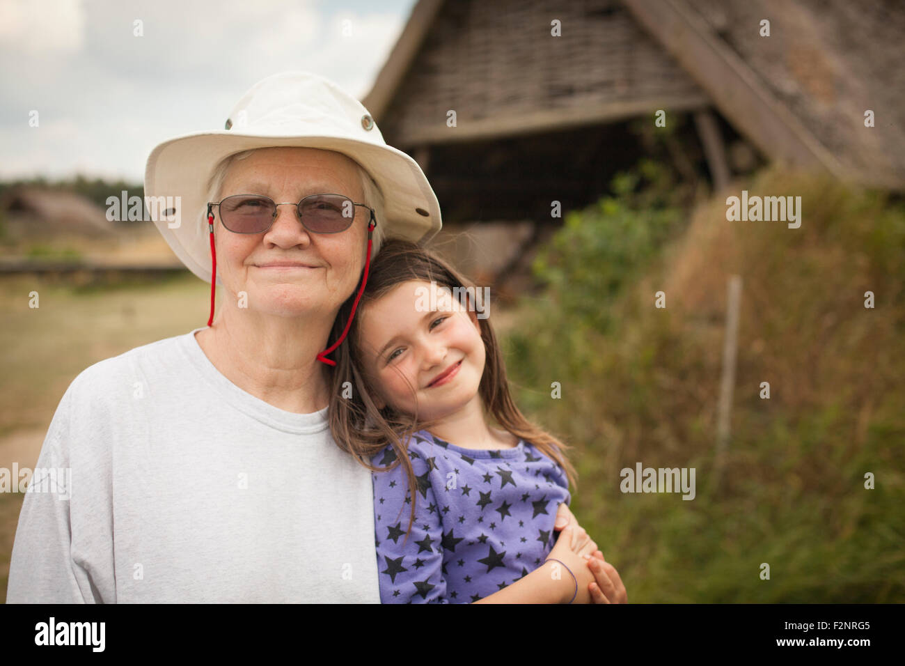 Kaukasische Großmutter umarmt Enkelin im Hinterhof Stockfoto