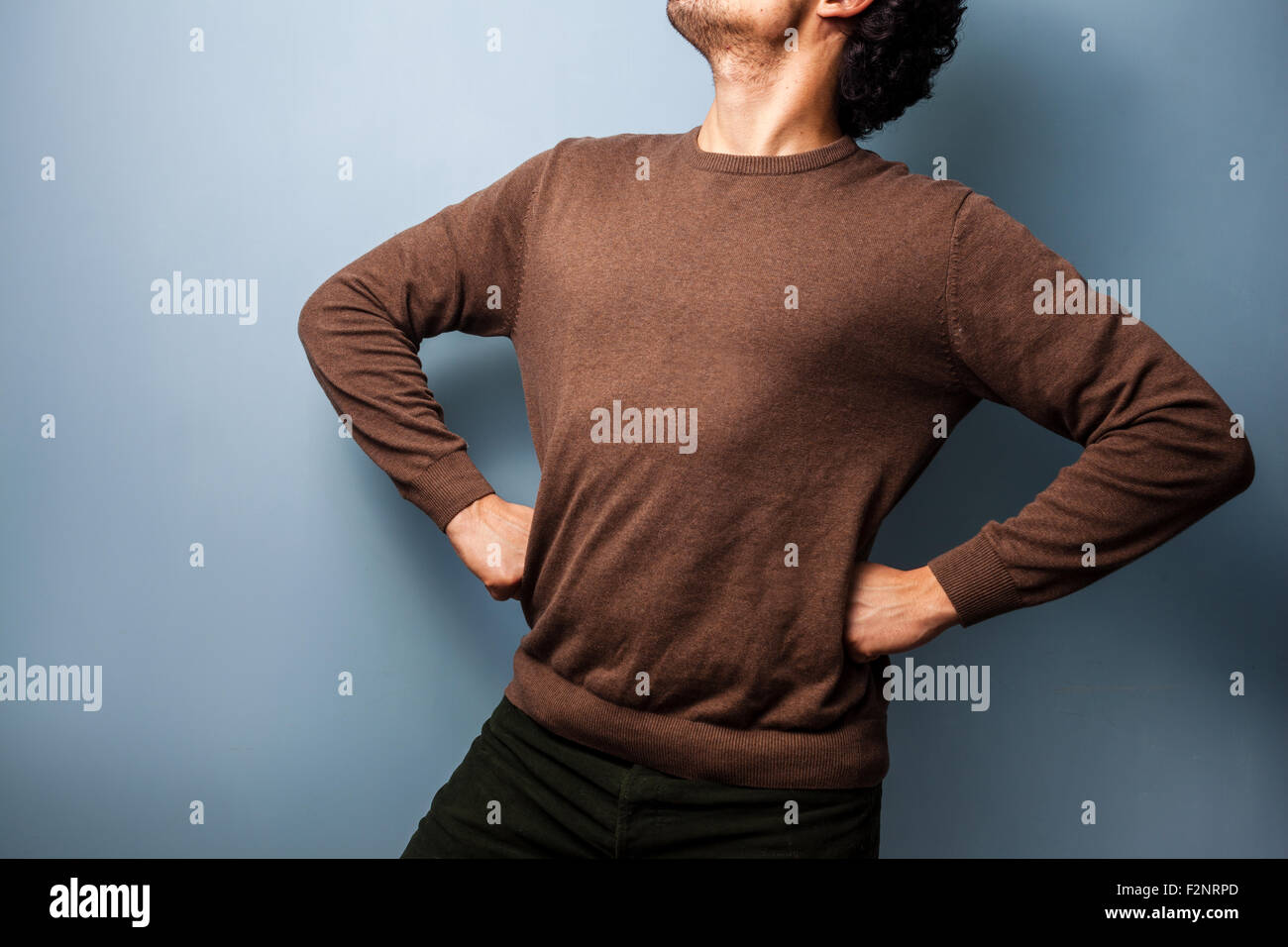 ein anonymen junger Mann steht stolz mit seinen Händen in den Hüften. Stockfoto