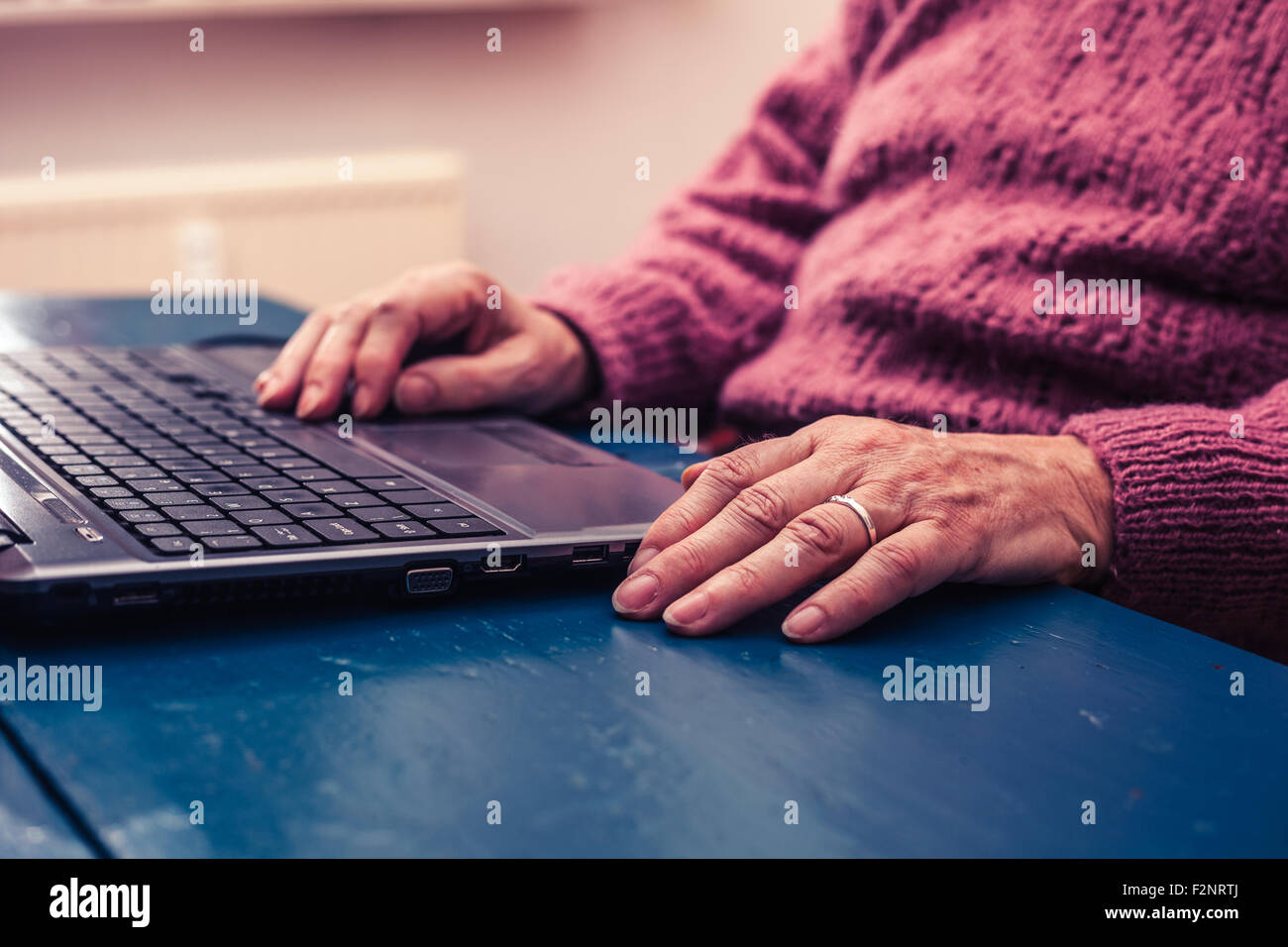 die Hände einer reifen Frau, die Eingabe über die Tastatur Stockfoto