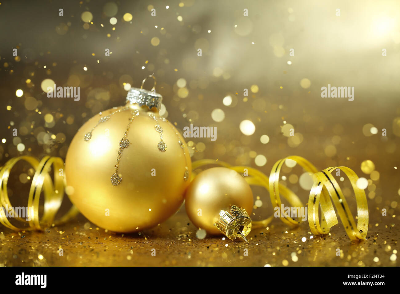 Goldene Weihnachtskugeln auf Glitzer Hintergrund Stockfoto