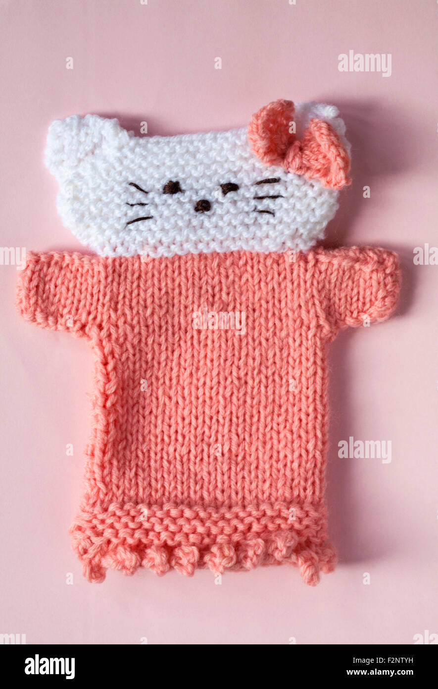 Hallo gestrickte Kitty Hand Handpuppe auf rosa Hintergrund Stockfoto