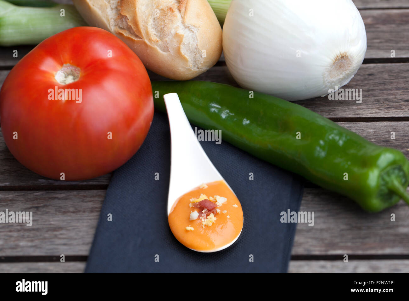 Salmorejo servieren Löffel umgeben von einigen der Zutaten für dieses Gericht zu machen. Stockfoto