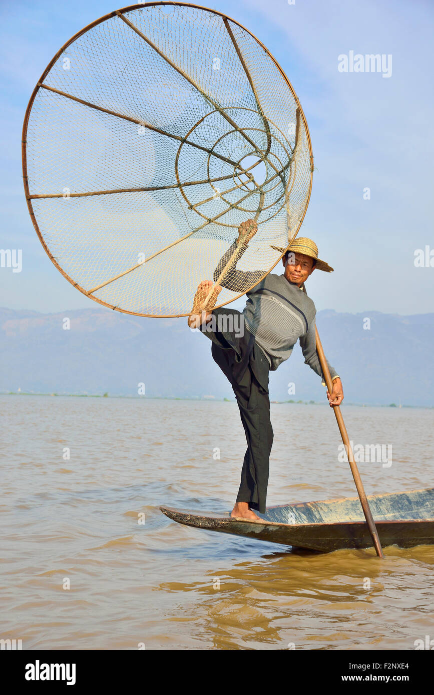 Inle See, Myanmar (Birma) lokale Fischer, der Intha, steht auf einem Bein, so dass er mit den anderen Paddel kann als Sie jagen Karpfen und andere Fische. Stockfoto