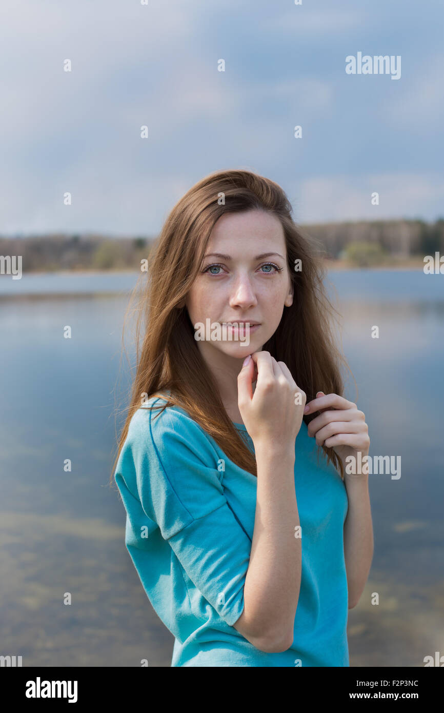 Sommersprossige glückliches Mädchen Blick in die Kamera und träumen am See Stockfoto