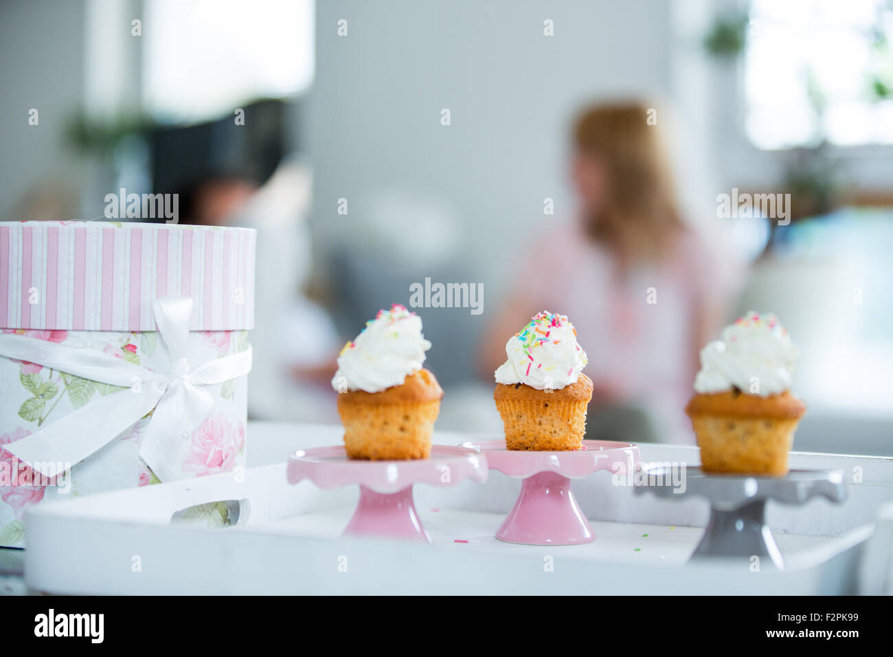 Drei Tasse Kuchen auf Tablett, Menschen im Hintergrund Stockfoto
