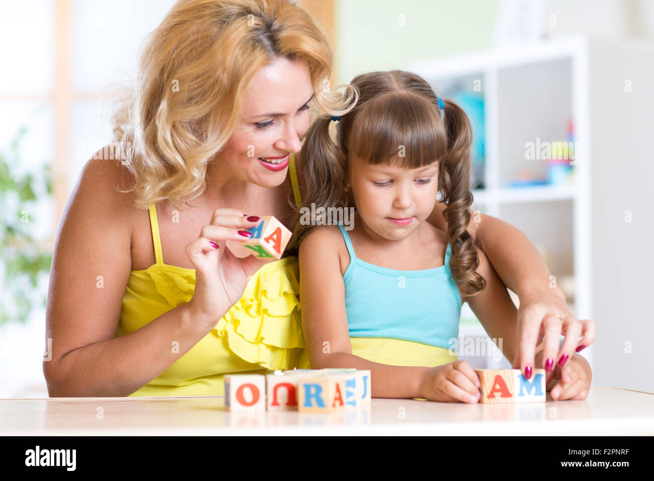 Kind und Mutter das Wort Mama spielen hölzerne Würfel bauen Stockfoto