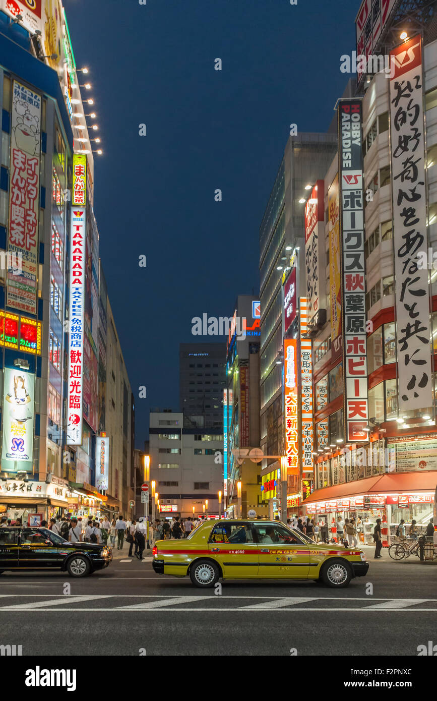 Ein Taxi in den Abend Berufsverkehr in Akihabara mit hellen Neon Werbung im Hintergrund stecken Stockfoto