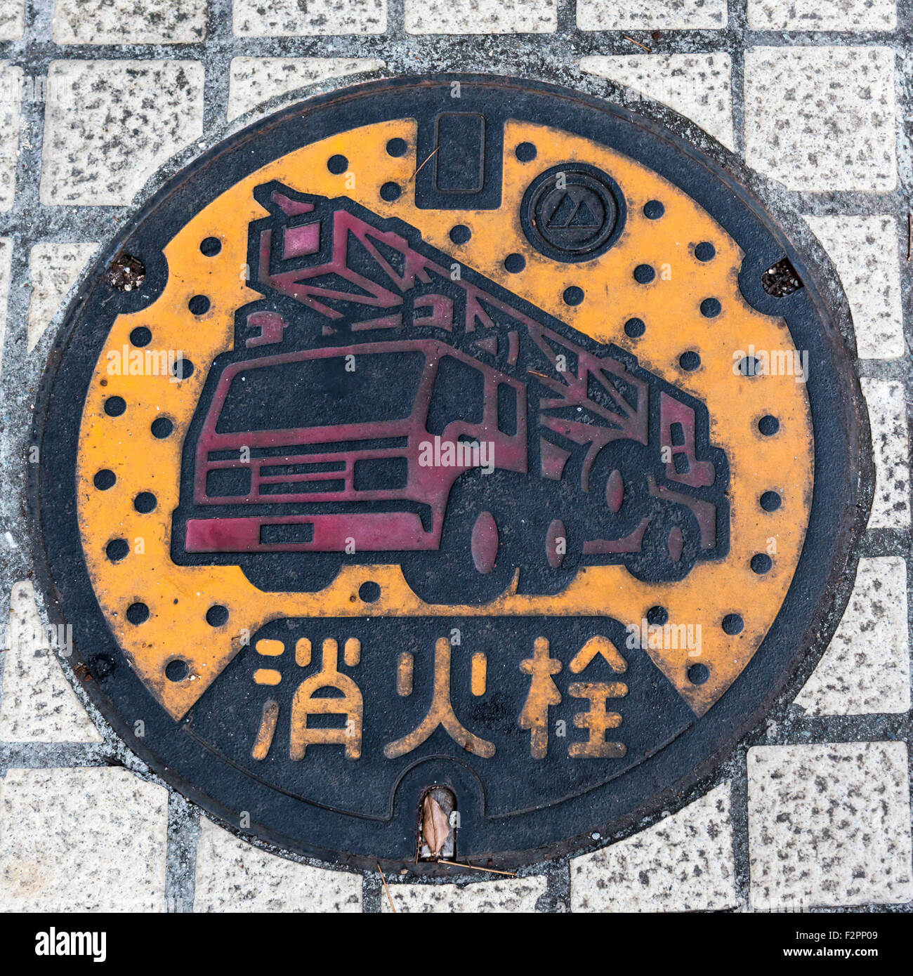 Runde Schachtabdeckung in einem Pfad mit den Worten "Fire Hydrant" auf Japanisch drauf Stockfoto