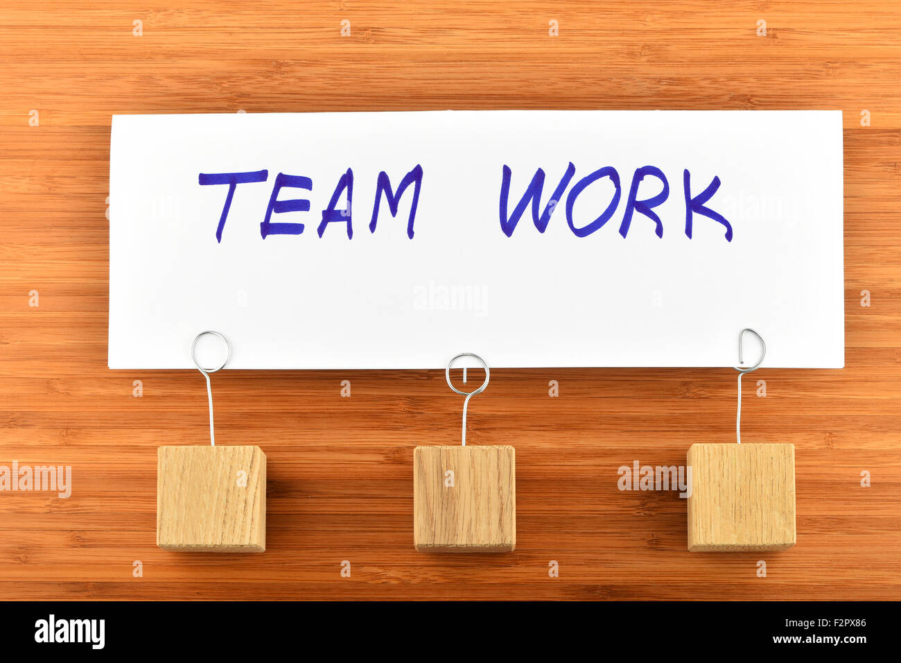 Team arbeiten, ein großes weißes Papier Hinweis mit drei hölzerne Halterung aus Holz Bambus Hintergrund für die Präsentation Stockfoto