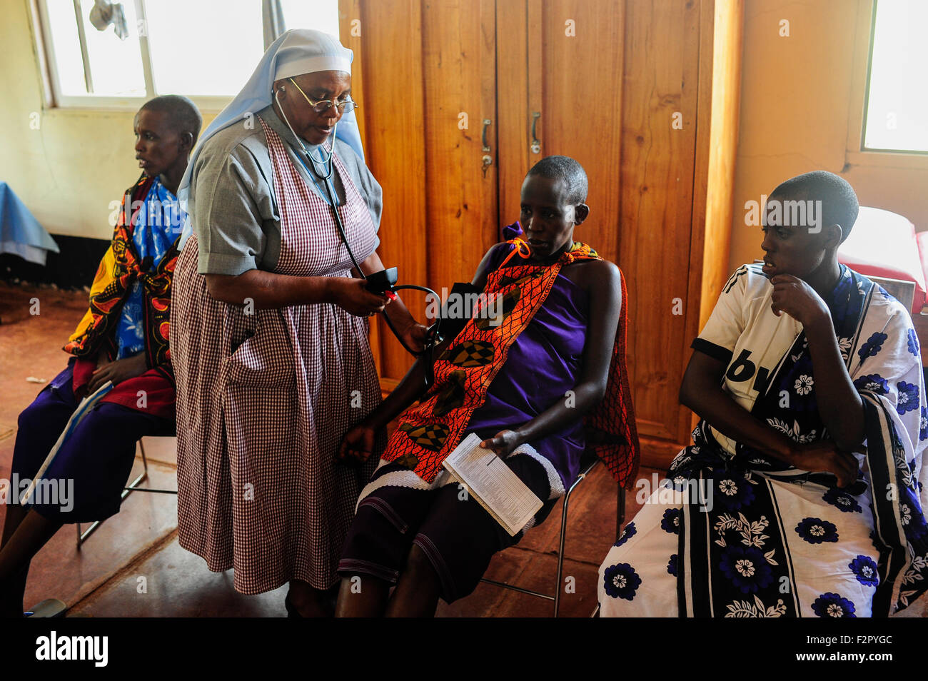 TANSANIA, Korogwe, Dorf Kwalukonge, KWALUKONGE GESUNDHEITSZENTRUM, Beratung für Schwangere Massai Frauen, stillende Schwester bei der Arbeit, Blutdruckmessung / TANSANIA, Korogwe, KWALUKONGE GESUNDHEITSZENTRUM, Krankenhaus der Rosminian Fathers und Usambara Schwestern in Kwalukonge, Schwangerschaftsberatung, Schwester Sr. JEREMIA, Blutdruckmessung Frauen Stockfoto