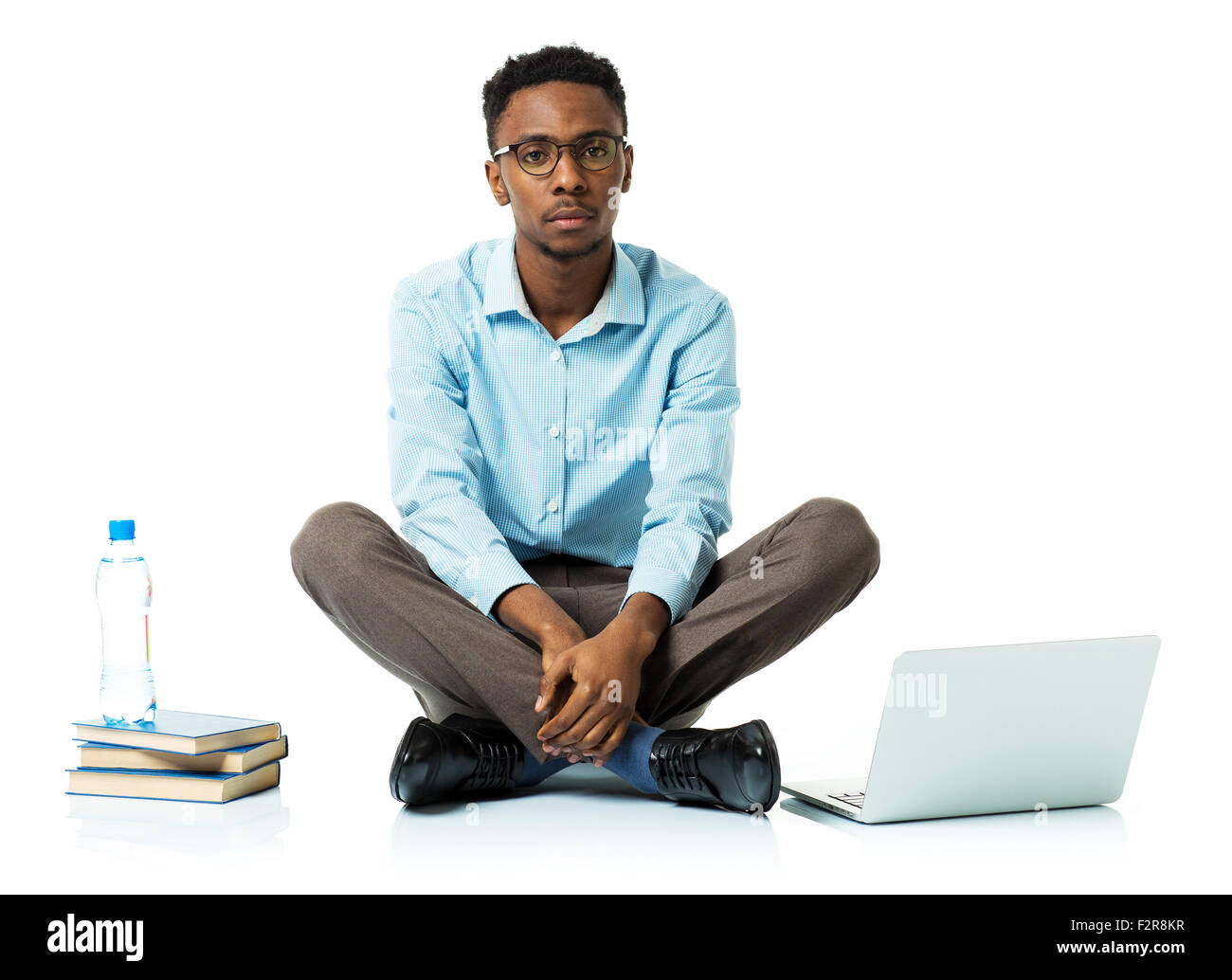 Schwere afrikanische amerikanische Studentin mit Laptop, Bücher und eine Flasche Wasser sitzen auf weißem Hintergrund Stockfoto