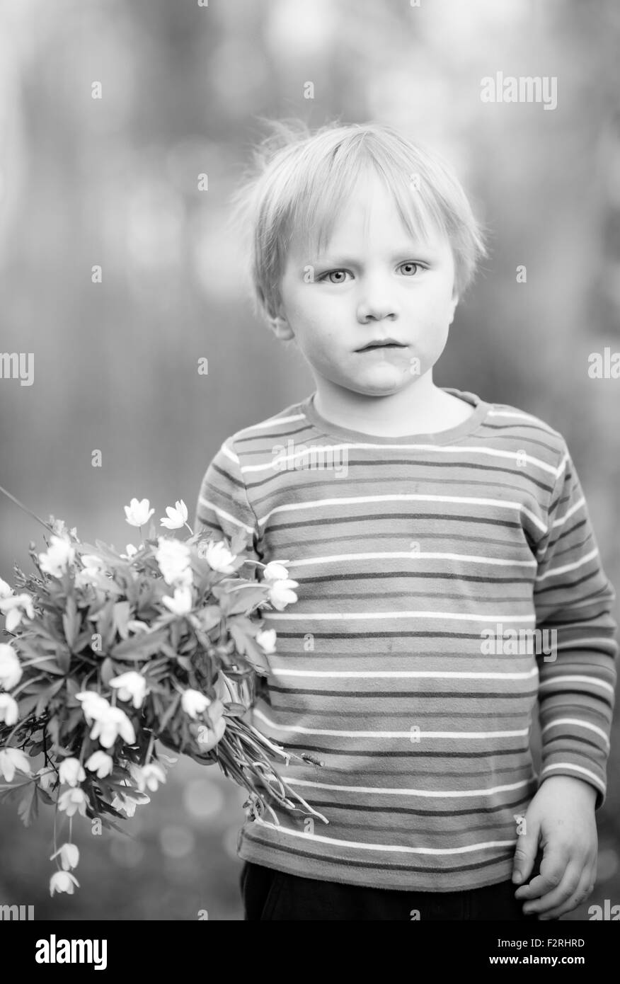 Kleiner Junge mit Waldblumen (Anemone) Stockfoto