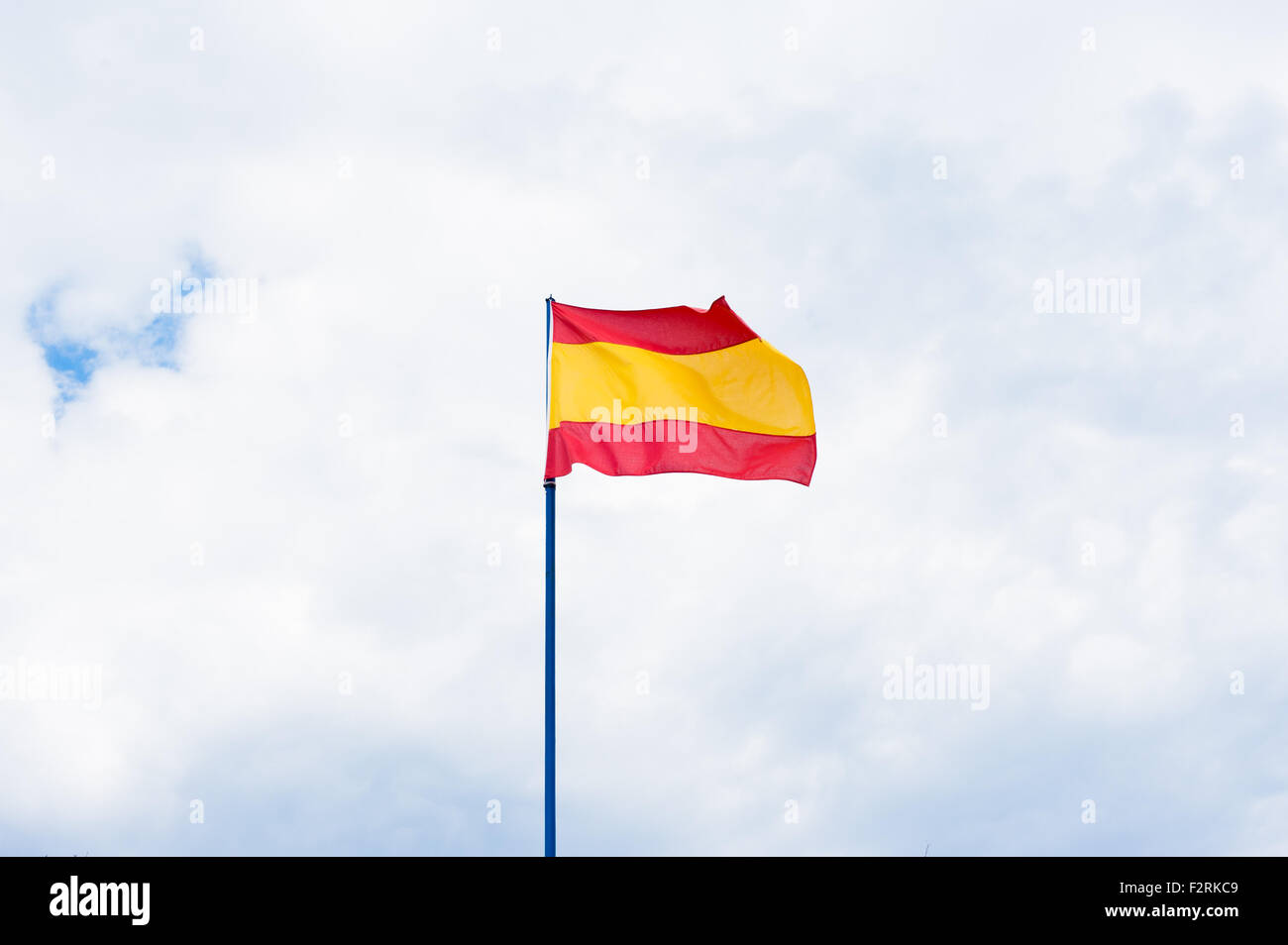 Spanische Flagge in bewölkter Himmel mit Textfreiraum Stockfoto