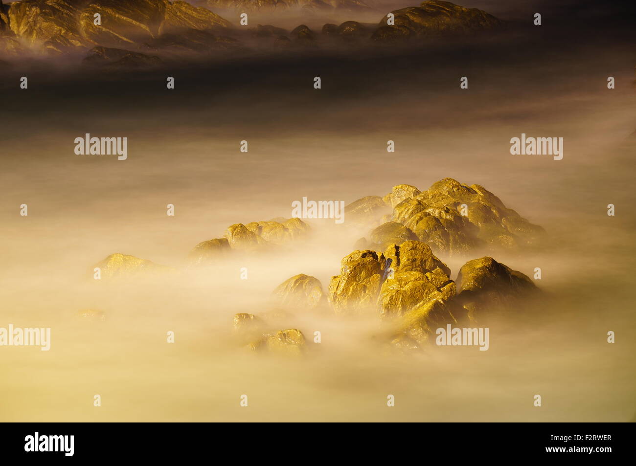 Golden Rock mit glatte Welle Stockfoto