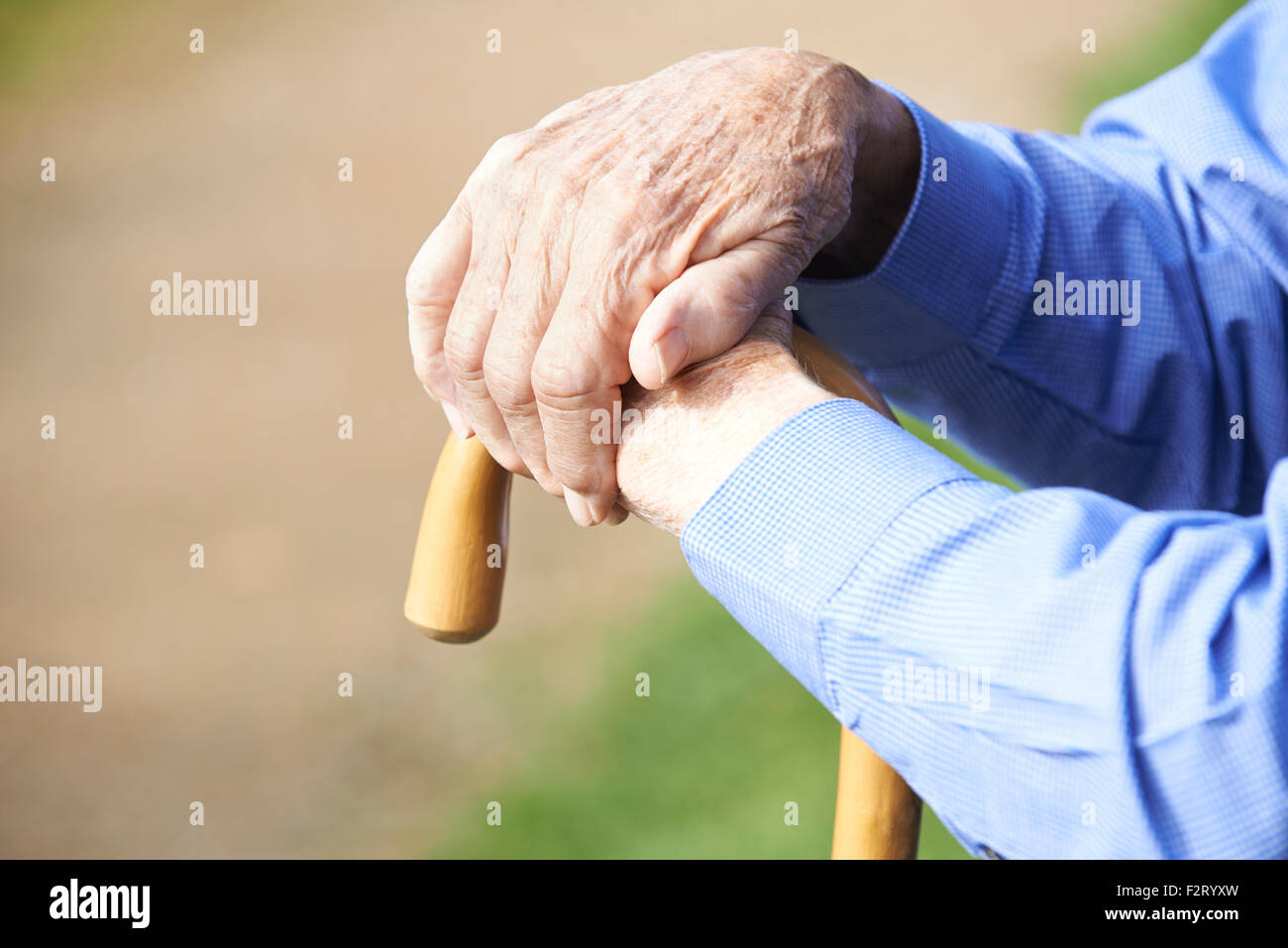 Nahaufnahme eines älteren Mannes Hände ruhen auf Spazierstock Stockfoto