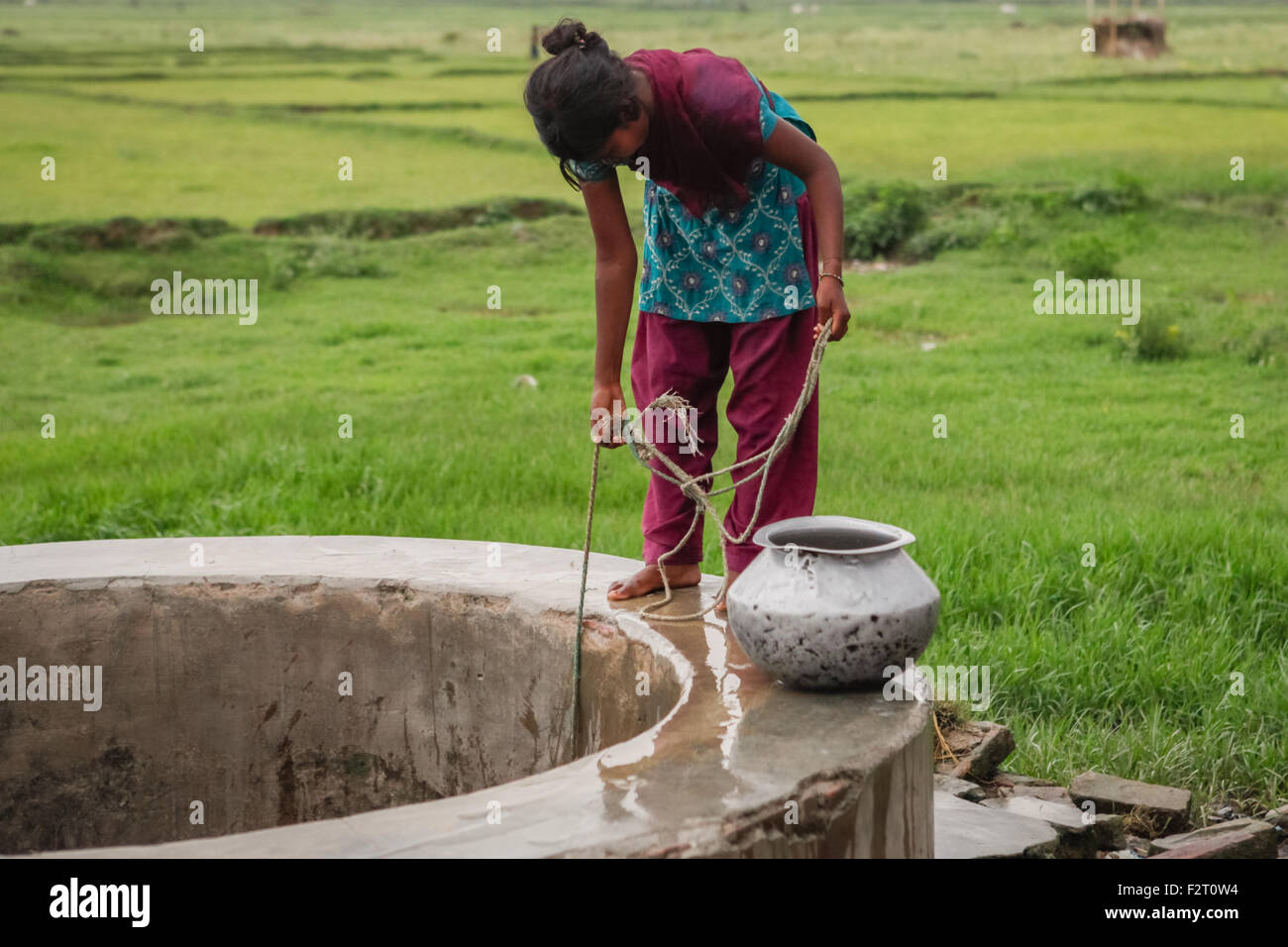 Eine Frau nimmt Wasser aus einem kommunalen Brunnen im ländlichen Teil von Gaya in Bihar, Indien. Stockfoto