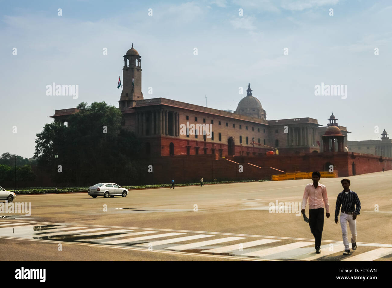 Menschen laufen auf dem Rajpath Boulevard im Hintergrund des indischen Sekretariatsgebäudes auf dem Raisina Hill in Neu-Delhi, Delhi, Indien. Stockfoto