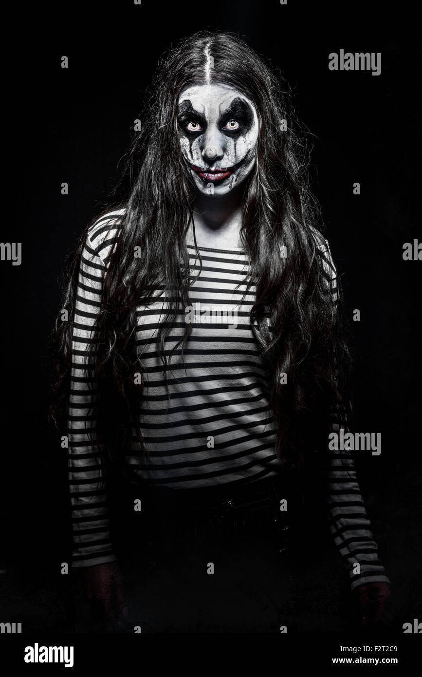 ein unheimlich böse Clown-Mädchen mit einem bösen Make-up Stockfoto